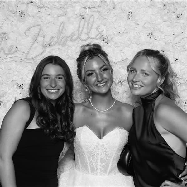 Bride and bridesmaids laughing together in a photo booth at the Zieball wedding reception